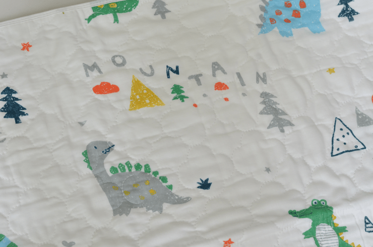 Swaddies PH Water Absorbent bed mat in dinosaur print.
