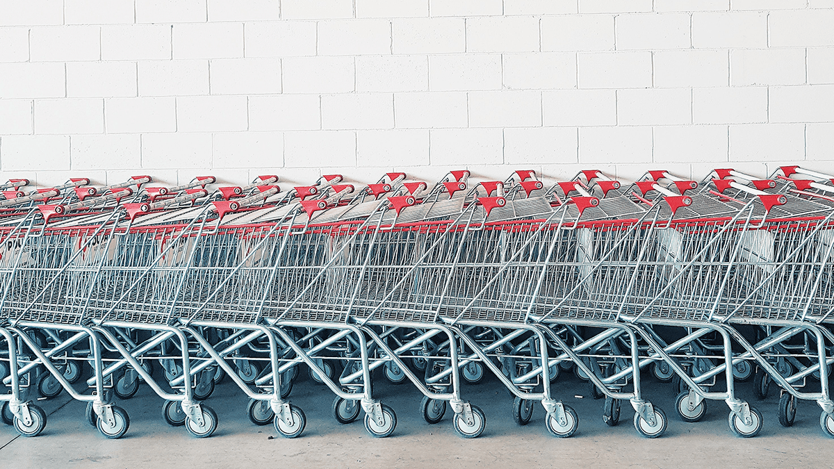 A line of push carts against a white tiled wall