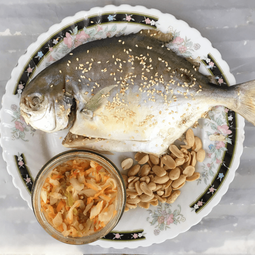 Steamed Pampano Fish topped with sesame seeds and served with curtido and nuts