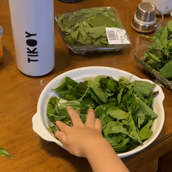 A toddler lends a hand in the kitchen