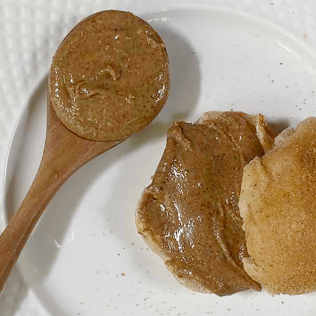 Close up of peanut better on a spoon and pandesal