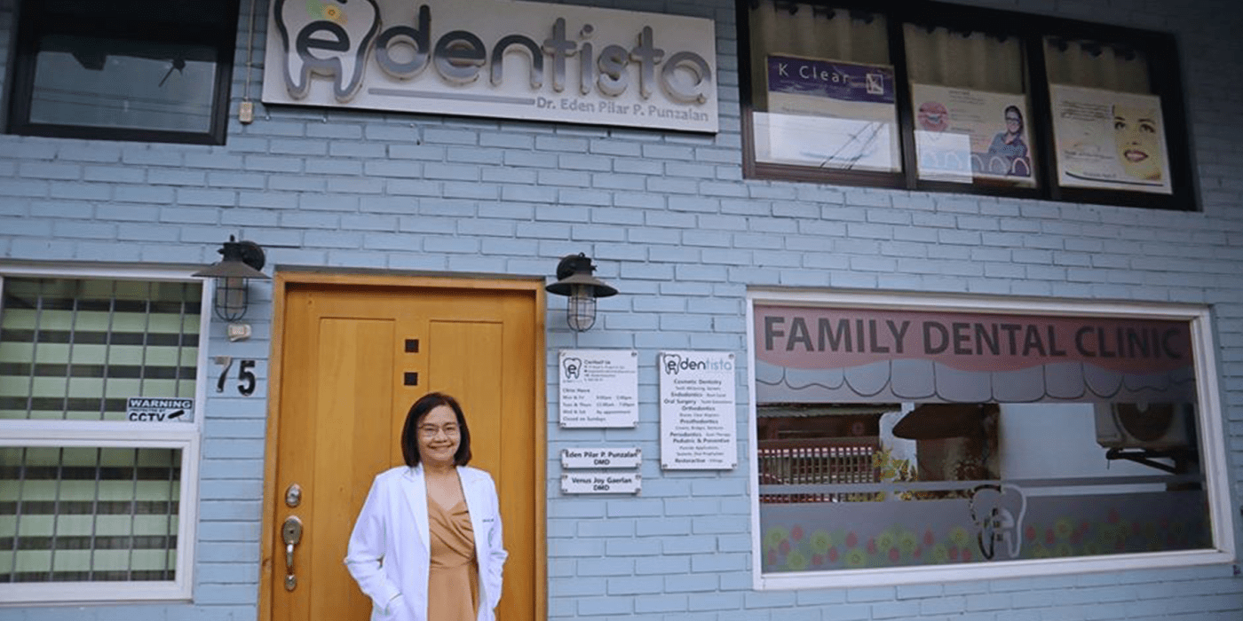 A dentist standing outside her dental clinic
