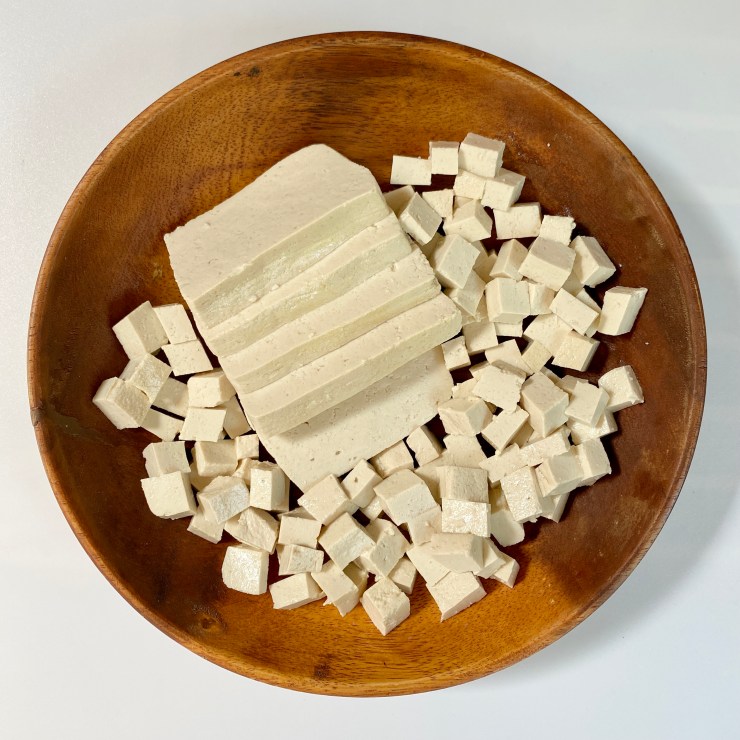 Diced tofu on a wooden plate