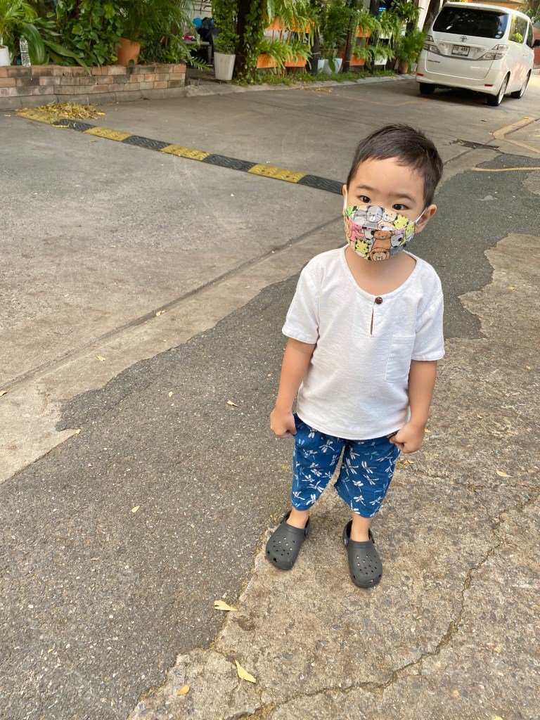 Little boy wearing KF94 mask for kids at the school parking lot