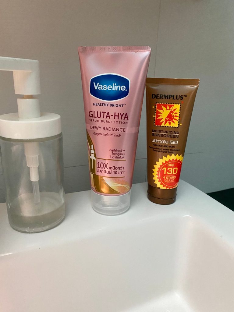 A bottle of Vaseline Gluta Hya Lotion next to a sunblock