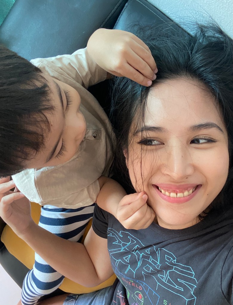 Little boy playing with his mom's hair