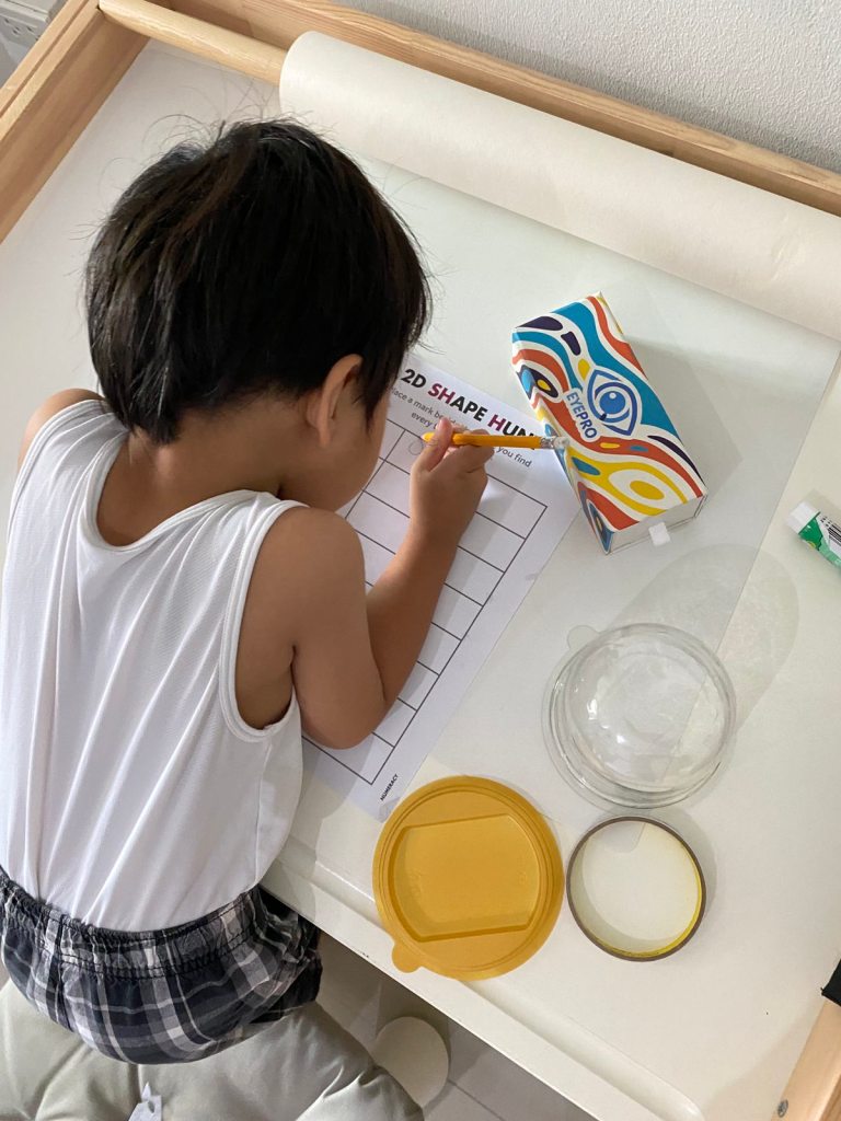 Little boy drawing household items for his shape hunt activity