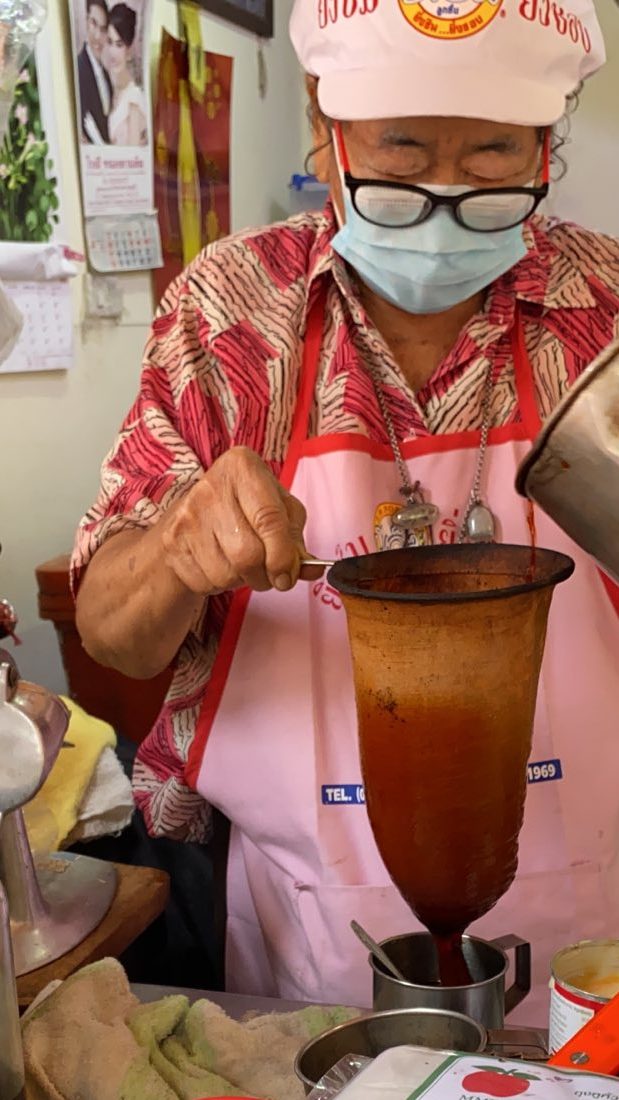 Thai milktea vendor Straining the brewed Thai milk tea leaves.
