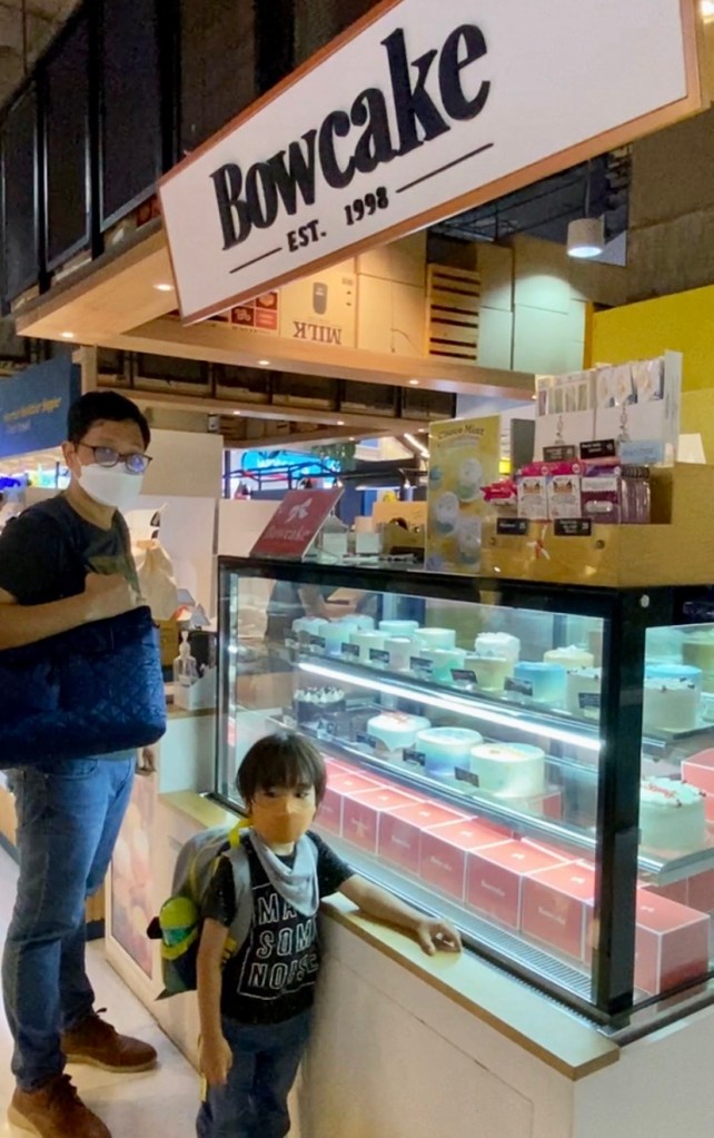 Father and son buying cake from Bowcake stall