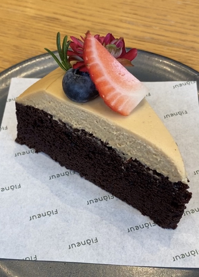 Chocolate earl grey cake topped with fresh fruits and edible flower