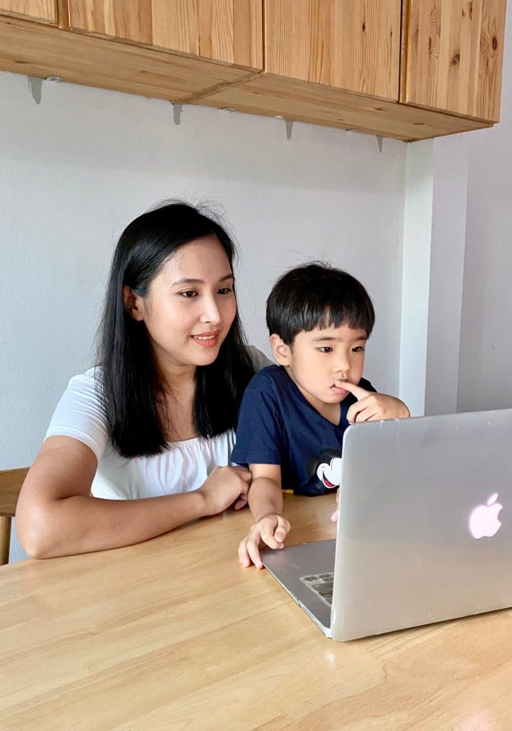 Mom and son attending an online tutorial session with a mac
