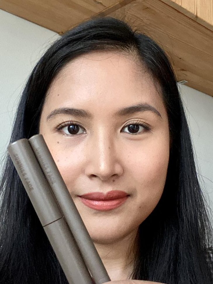 Smiling woman showing her brow makeup