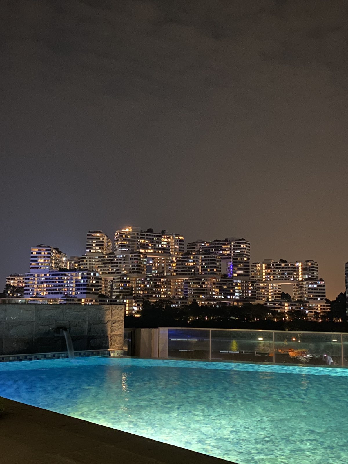 night time at the pool with the city buildings as a view