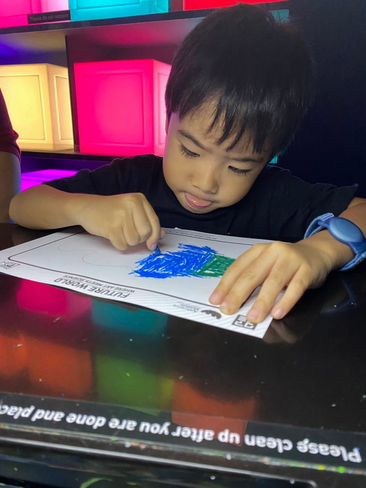 Little boy drawing with his tongue out