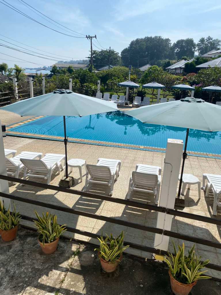 Pool area with beach chairs and umbrellas