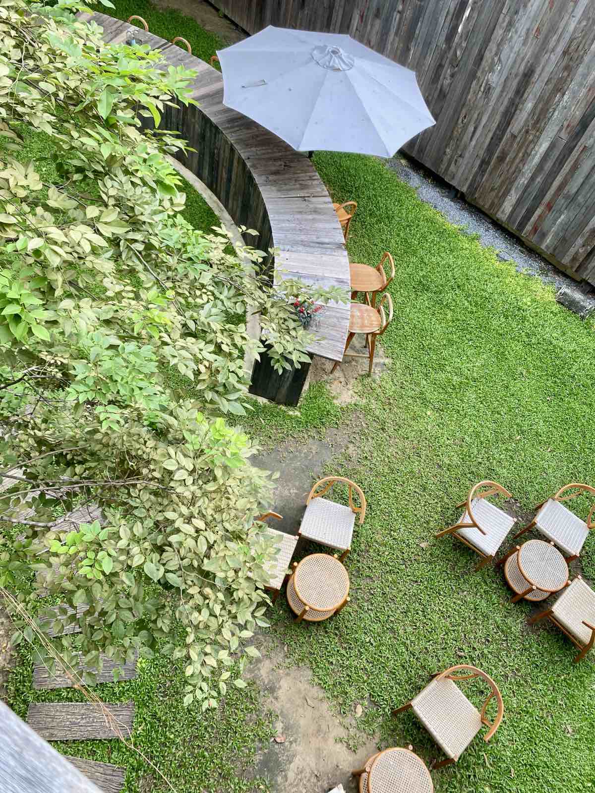 Top view of a rustic garden cafe with a line of wooden bench and stools