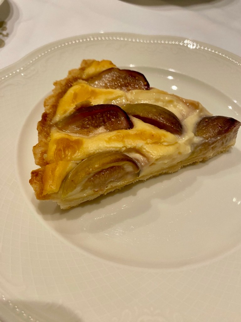 A white plate with a slice of fig pie