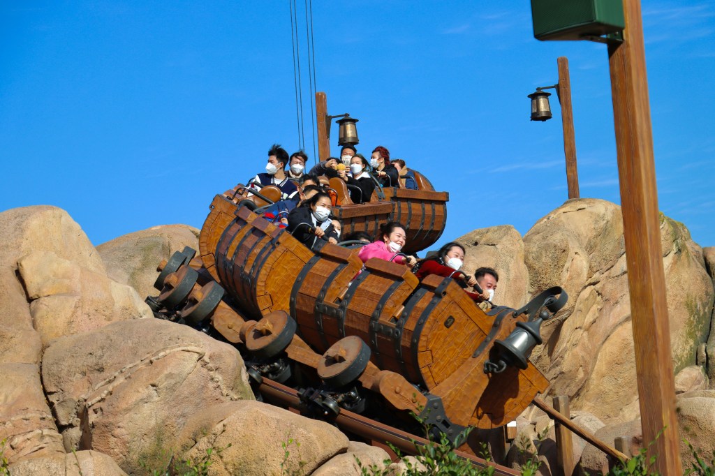 people riding a wooden themed roller coaster
