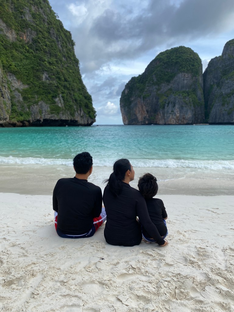 A family sitting on a beach together enjoying the view
